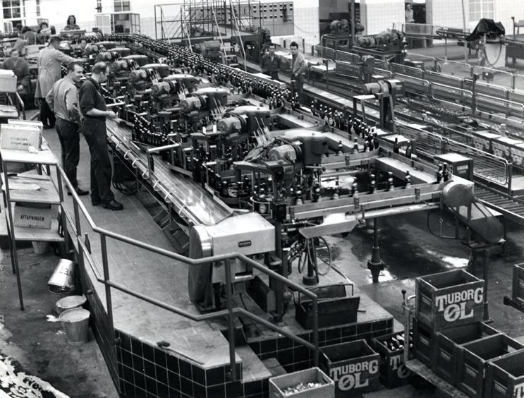 Samlebånd og maskiner tager over. 70 år senere er der ikke mange mennesker tilbage i tappehallen. Maskiner og samlebånd dominerer, mens et par medarbejdere overvåger produktionen. Produktionen var også blevet noget mere effektiv: Nu kunne man fremstille 30.000 øl i timen.